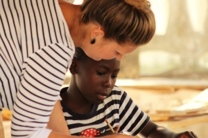Melanie (volunteer) helps Winstoni write his story.