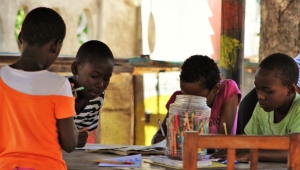 Children drawing and writing around the table.