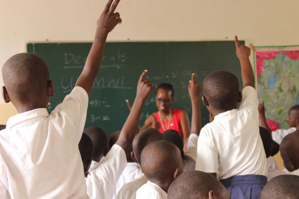 Many kids raise their hand in the classroom