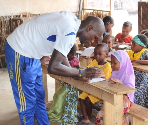 Moses, our local volunteer, aids a student in her handwriting